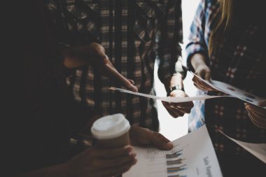 Ekose gömlekli bir kadın ve erkek çalışan bir grup insan iş yapma hakkında konuşuyor / danışmanlık yapıyor. Takım çalışması iş toplantısı