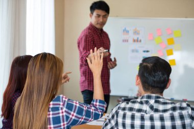 Sıradan ekose gömlek giyen Asyalı genç kadınların eli konferanstaki meslektaşlarından başarılı bir iş yürütme konusunda geri bildirim istiyor. Takım çalışması iş toplantısı