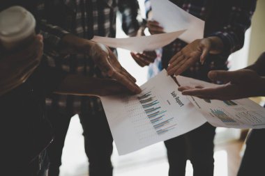 Ekose gömlekli bir kadın ve erkek çalışan bir grup insan iş yapma hakkında konuşuyor / danışmanlık yapıyor. Takım çalışması iş toplantısı