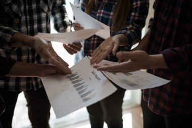 Ekose gömlekli bir kadın ve erkek çalışan bir grup insan iş yapma hakkında konuşuyor / danışmanlık yapıyor. Takım çalışması iş toplantısı