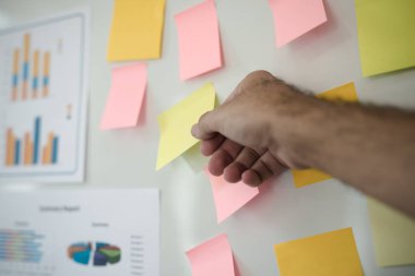 Elinde post-it tutan adamın eli. Beyin Fırtınası Strateji Atölyesi.