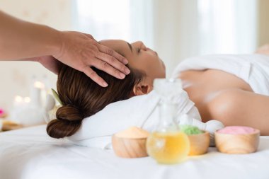 Güzel Asyalı kız güzellik salonunda yüz masajı yaptırıyor.