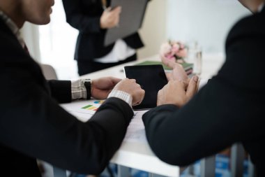 Asyalı iş adamları grubu toplanıyor. Planlamayı sunmak için dijital tablet kullanarak. Konsept Takım Çalışması