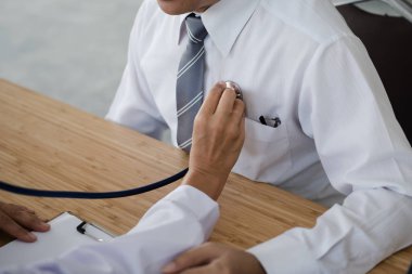 Bir hasta stetoskop tıbbi ofis ile inceleyerek doktor el