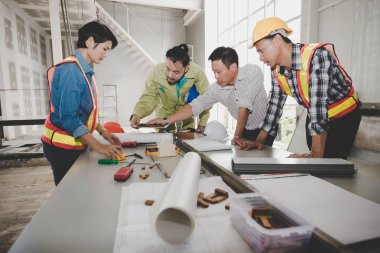 Bir grup erkek ve kadın mühendis bina inşaatı için planları hakkında konuşmak toplantı. ekip çalışması kavramı