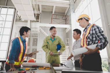 Bir grup erkek ve kadın mühendis bina inşaatı için planları hakkında konuşmak toplantı. ekip çalışması kavramı