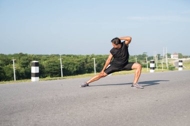 Erkek koşucu sabah koşuya hazırlanmak için bacak kasları germe. Sağlık ve fitness kavramı
