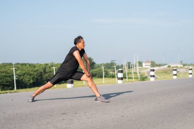 Erkek koşucu sabah koşuya hazırlanmak için bacak kasları germe. Sağlık ve fitness kavramı