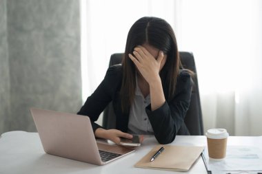 Genç Asyalı işkadını hissediyorum vurguladı/endişe/baş ağrısı/hayal kırıklığına office oturup süre çalışma sırasında
