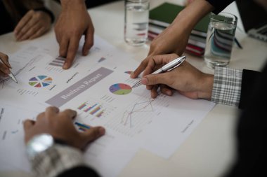 İş adamının eli grafiği gösteriyor. Konferans odasında oturup Rapor, Satış, Hedef, Pazarlama, Konsept hakkında konuşacağız..