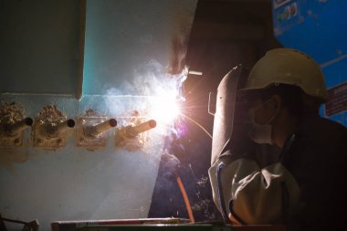 Adam kaynakçı makineleri sanayi tesisleri tam koruyucu giysi ile çalışma. Emanet kask, eldiven, Kaynak Kasklar. Emanet iş yeri kavramı