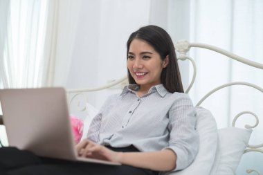 Asya iş kız mutlu ve gülümseme ile bir dizüstü bilgisayar çalışırken 