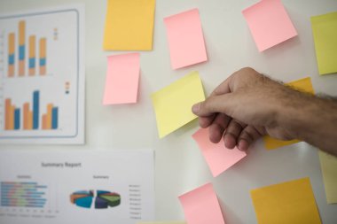 Elinde post-it tutan adamın eli. Beyin Fırtınası Strateji Atölyesi.