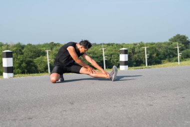 Erkek koşucu sabah koşuya hazırlanmak için bacak kasları germe. Sağlık ve fitness kavramı