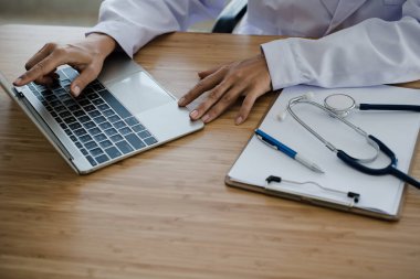 Genç doktor oturma çalışma masanın üstünde laptop ile