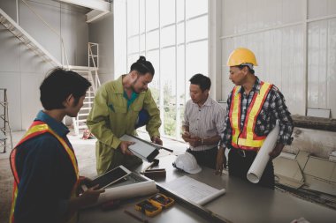 Bir grup erkek ve kadın mühendis bina inşaatı için planları hakkında konuşmak toplantı. ekip çalışması kavramı