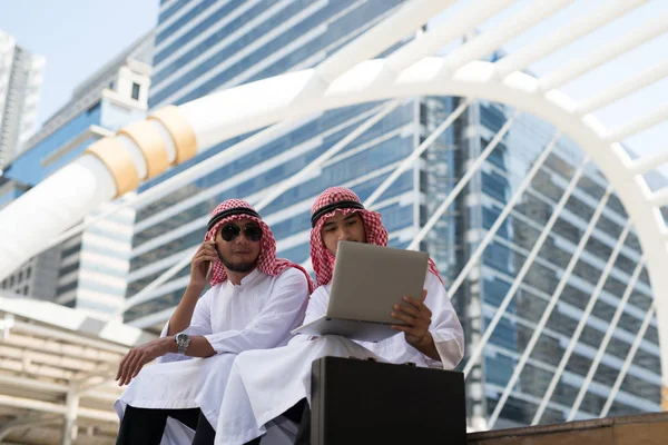 Два Молодых Арабских Бизнесмена Сидят Разговаривают Работая Ноутбуком Фоне Города — стоковое фото