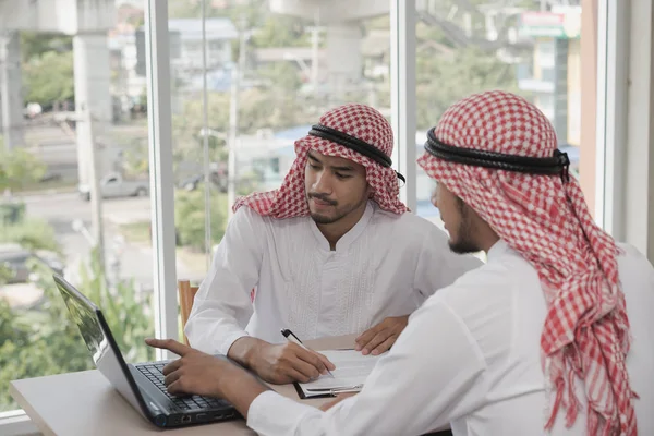 İki iş adamı bir dizüstü bilgisayarla çalışıyor. İş analizi yapıyorlar, tartışıyorlar. Beyin fırtınası, takım çalışması, toplantı konsepti.