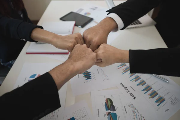 Fist bump. Hand of business men and women at their desks. Business teamwork concept