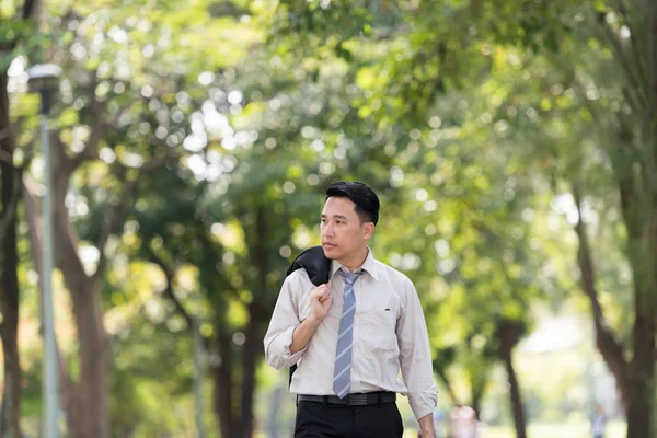 Young Asia businessman showing stress face. He was walking in the Park.