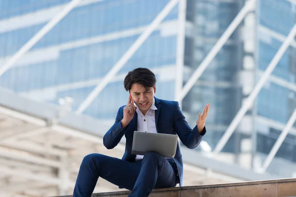 Young Asian Businessman Talking Mobile Phone Serious Face Working Laptop – stockfoto