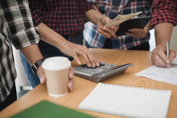 Grup işadamı ve kadın hesap makinesi kullanıyor. İş payını hesaplamış.