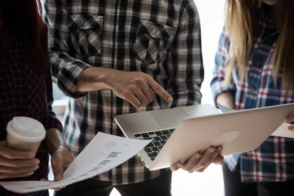 Ekose gömlekli bir kadın ve erkek çalışan bir grup insan çalışmak ve konuşmak için senin bilgisayarını kullanıyor. takım çalışması işi