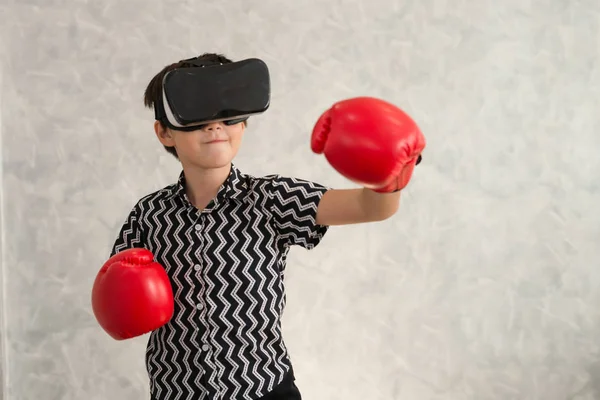A boy is playing boxing game with 3D virtual reality headset.