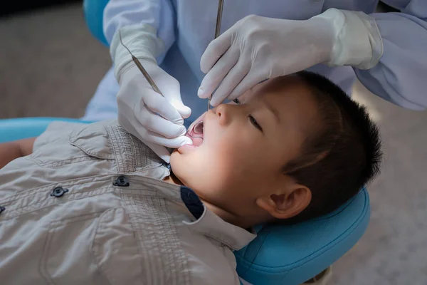 Ręce Dentysty Trzymającego Narzędzie Dentystyczne Sprawdzanie Zębów Chłopca Leżącego Krześle — Zdjęcie stockowe