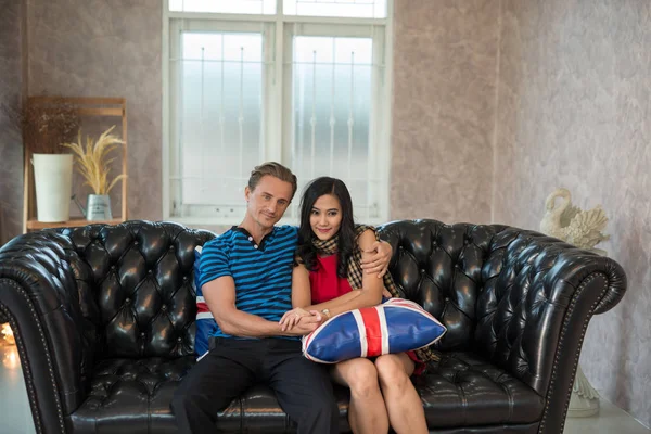 Kucaklayan, kanepede oturan iki genç aşıklar.