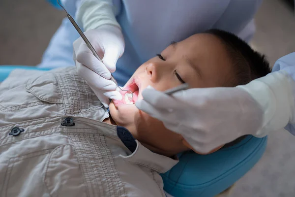 Ręce Dentysty Trzymającego Narzędzie Dentystyczne Sprawdzanie Zębów Chłopca Leżącego Krześle — Zdjęcie stockowe