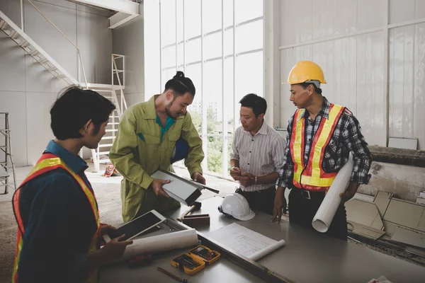 Bir grup erkek ve kadın mühendis bina inşaatı için planları hakkında konuşmak toplantı. ekip çalışması kavramı
