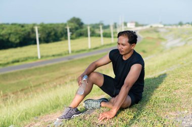 Asya genç erkekler içme suyu sabah koşu sonra otur. Sağlık ve fitness kavramı