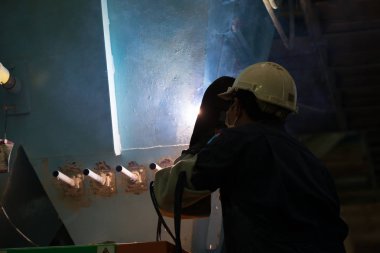 Adam kaynakçı makineleri sanayi tesisleri tam koruyucu giysi ile çalışma. Emanet kask, eldiven, Kaynak Kasklar. Emanet iş yeri kavramı