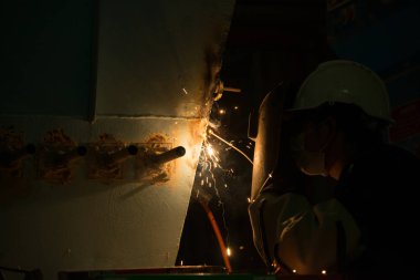 Adam kaynakçı makineleri sanayi tesisleri tam koruyucu giysi ile çalışma. Emanet kask, eldiven, Kaynak Kasklar. Emanet iş yeri kavramı