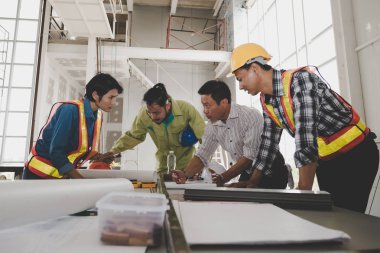 Bir grup erkek ve kadın mühendis bina inşaatı için planları hakkında konuşmak toplantı. ekip çalışması kavramı
