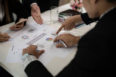 İş adamının eli grafiği gösteriyor. Konferans odasında oturup Rapor, Satış, Hedef, Pazarlama, Konsept hakkında konuşacağız..