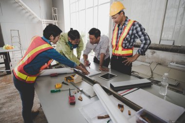 Bir grup erkek ve kadın mühendis bina inşaatı için planları hakkında konuşmak toplantı. ekip çalışması kavramı