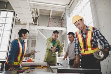 Bir grup erkek ve kadın mühendis bina inşaatı için planları hakkında konuşmak toplantı. ekip çalışması kavramı