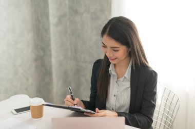 Güzel Asyalı Genç iş kadını. Mutlu onun iş istasyonu çalışma