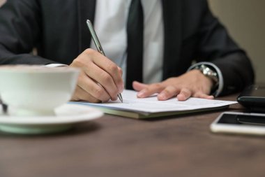 İşadamı yakından kahve dükkanında iş sözleşme detayları bir sözleşme imzalama
