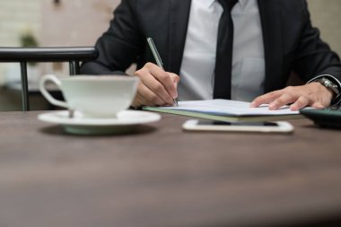 İşadamı yakından kahve dükkanında iş sözleşme detayları bir sözleşme imzalama