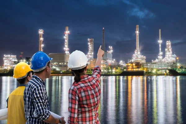 Asya mühendisler grubu petrol danışmak ve gaz rafineri tesisi alacakaranlık gece gökyüzü petrol veya Petrokimya sanayi üretiminin. Mühendislik kavramı.