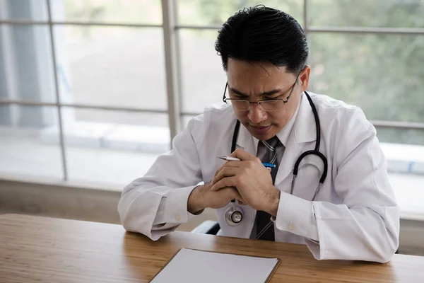 Masa başında, endişeli oturan, fazla düşünüp doktor. Hastaların tedavisi için