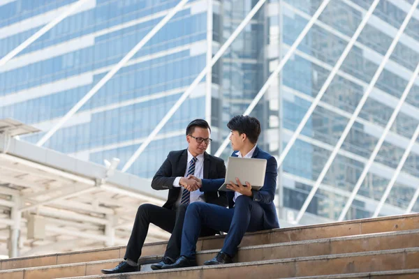 Successful two businessman in suit. He being handshaking in city, planning new projects, waiting for meeting to start. Copy space for text