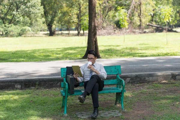 Businessman sit check email on digital tablet at the garden on the way back home.