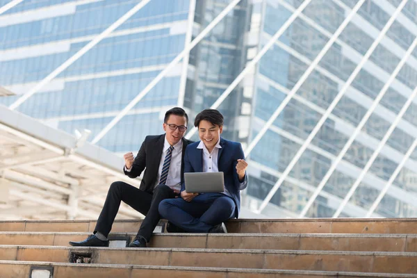 Başarılı heyecan Asya iş adamları grup takım birlikte siting ve yumruk Tamam Evet jest iş bölgesi arka planda tutan