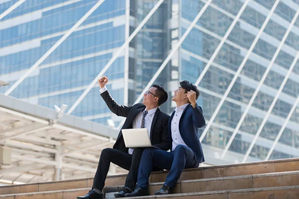 Başarılı heyecan Asya iş adamları grup takım birlikte siting ve yumruk Tamam Evet jest iş bölgesi arka planda tutan