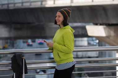 Mutlu traveler şehir kurma sırasında bir smartphone kullanarak taşıma için bekliyor