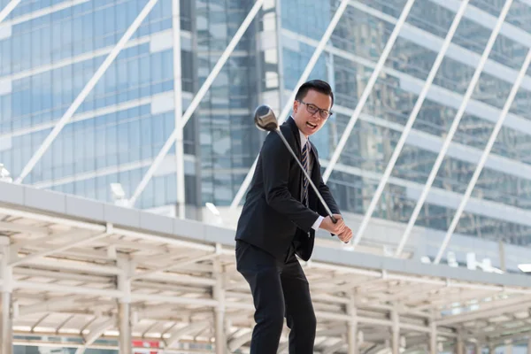 Takım elbiseli başarılı bir iş adamı. golf ekipmanları kentin ayakta tutan el. Şehir arka plan başarı kavramı